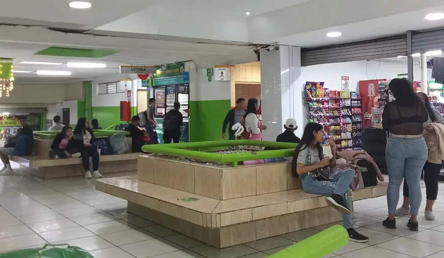 waiting area in bus terminal with people and stores